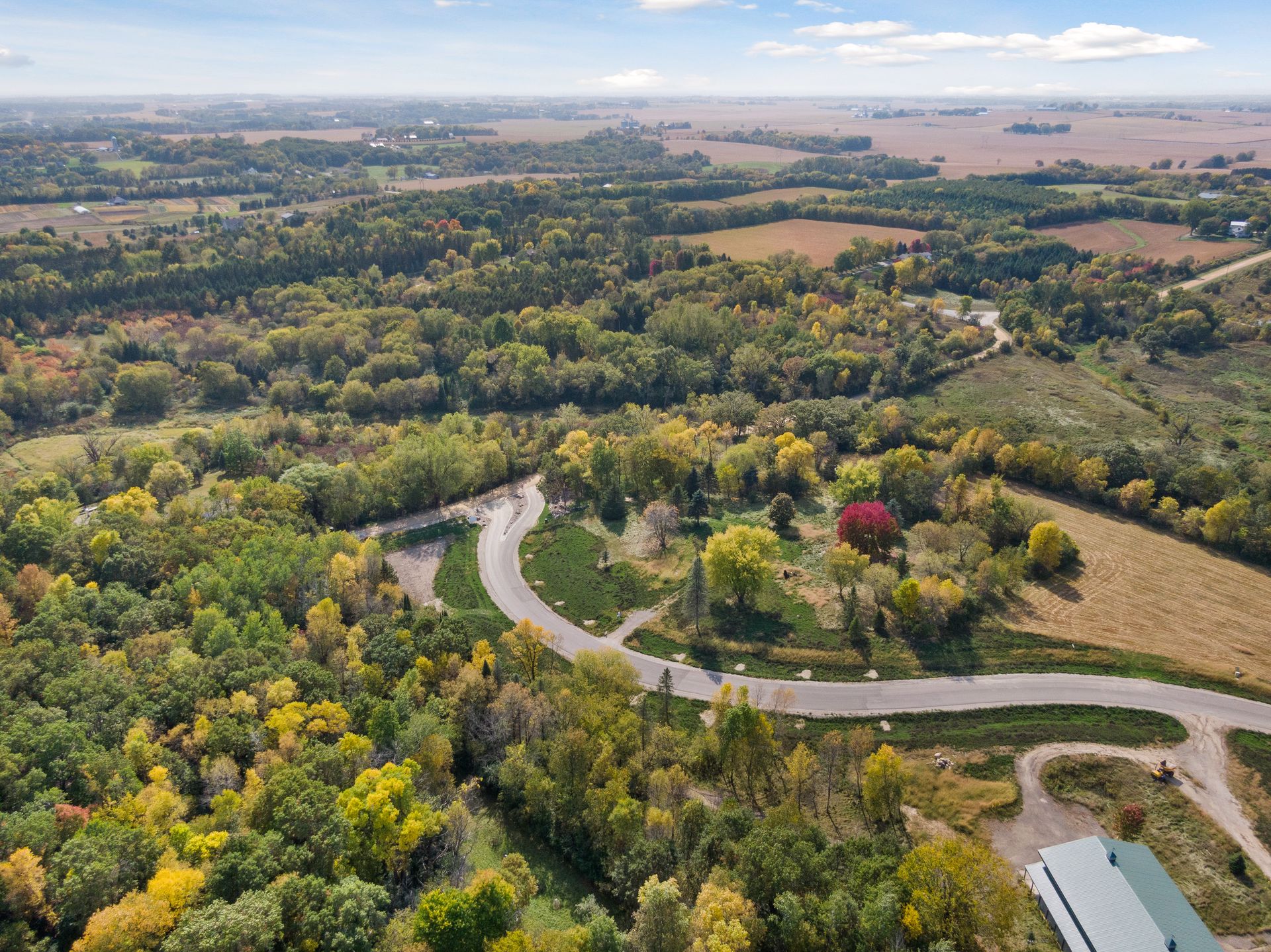 Afton bluff country in autumn, with wooded parcels, the surrounding valley, and the road winding through.